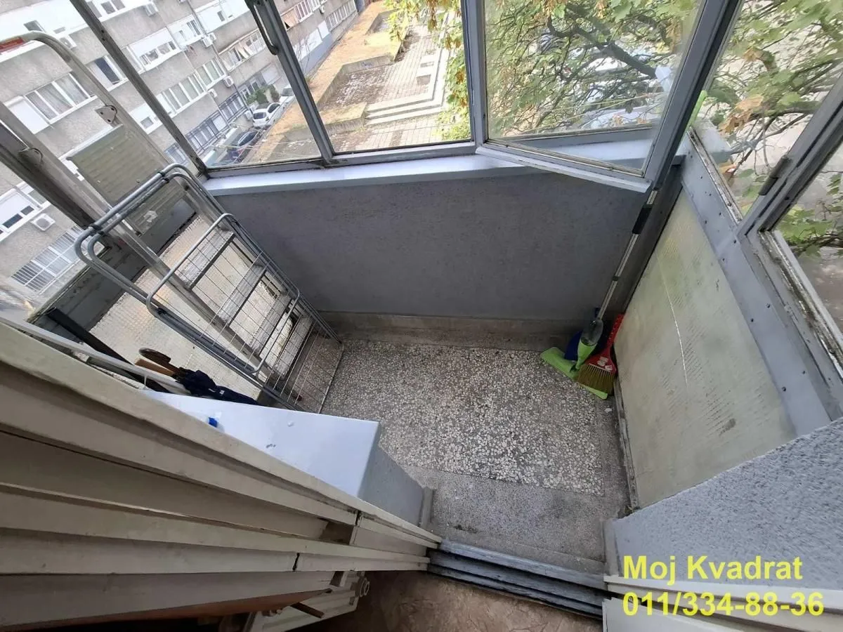 Enclosed balcony overlooking surrounding buildings and courtyard.