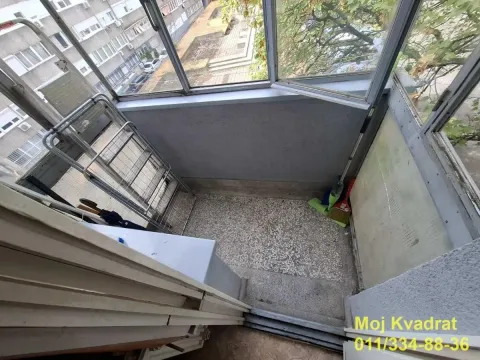 Enclosed balcony overlooking surrounding buildings and courtyard. - image 9