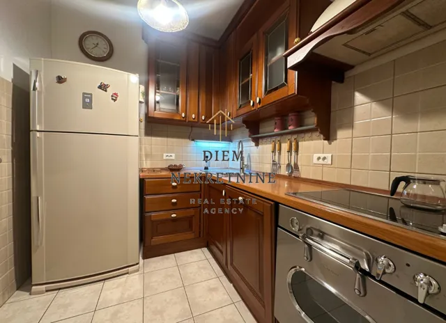 Kitchen equipped with wooden cabinetry and white goods.