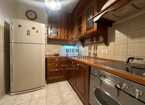 Kitchen equipped with wooden cabinetry and white goods. - image 6
