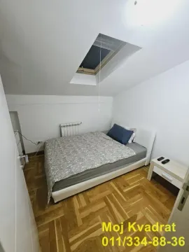 Spavaća soba sa bračnim krevetom i krovnim prozorom. - image 6