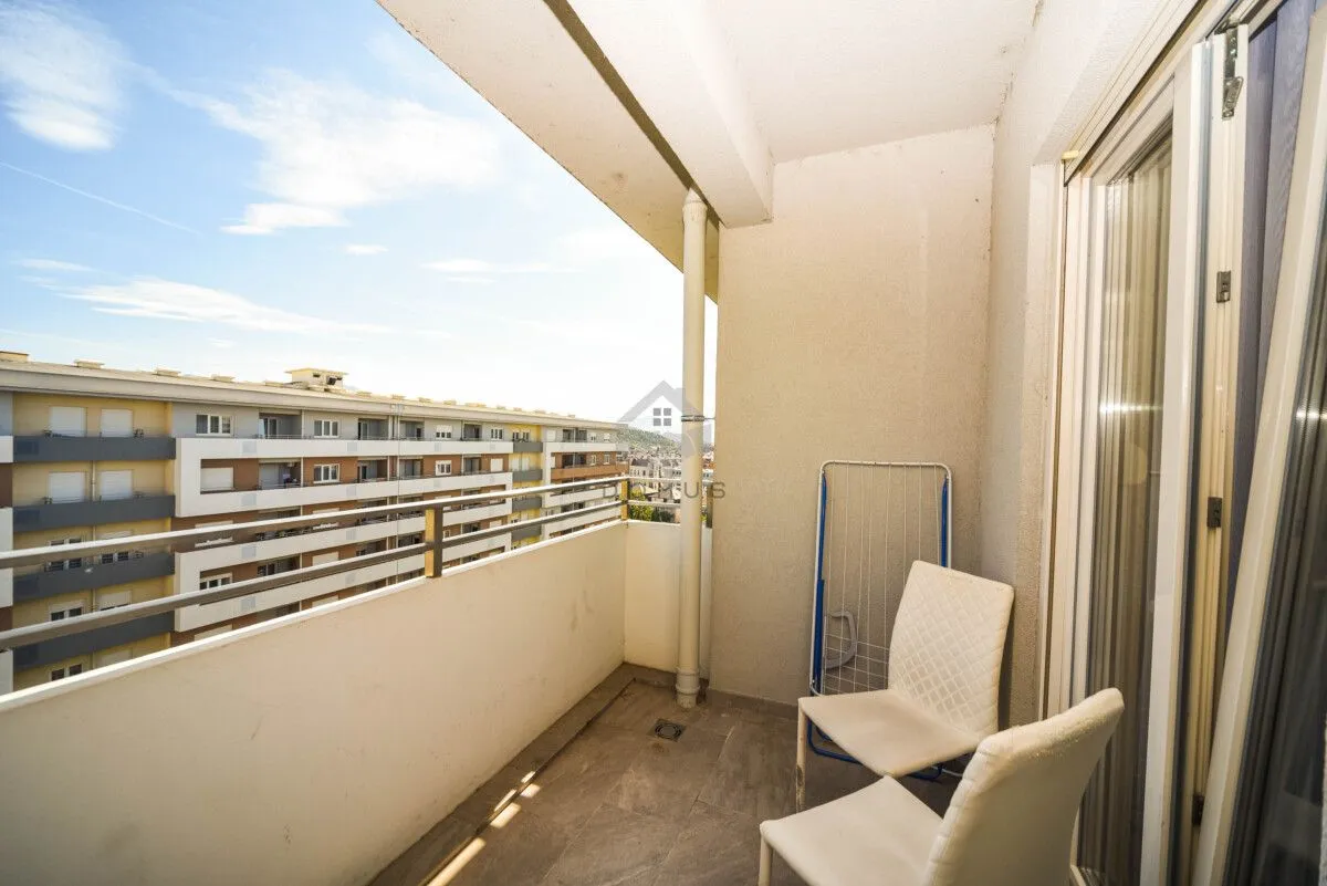 Natkriveni balkon sa stolicama i sušilicom za veš.