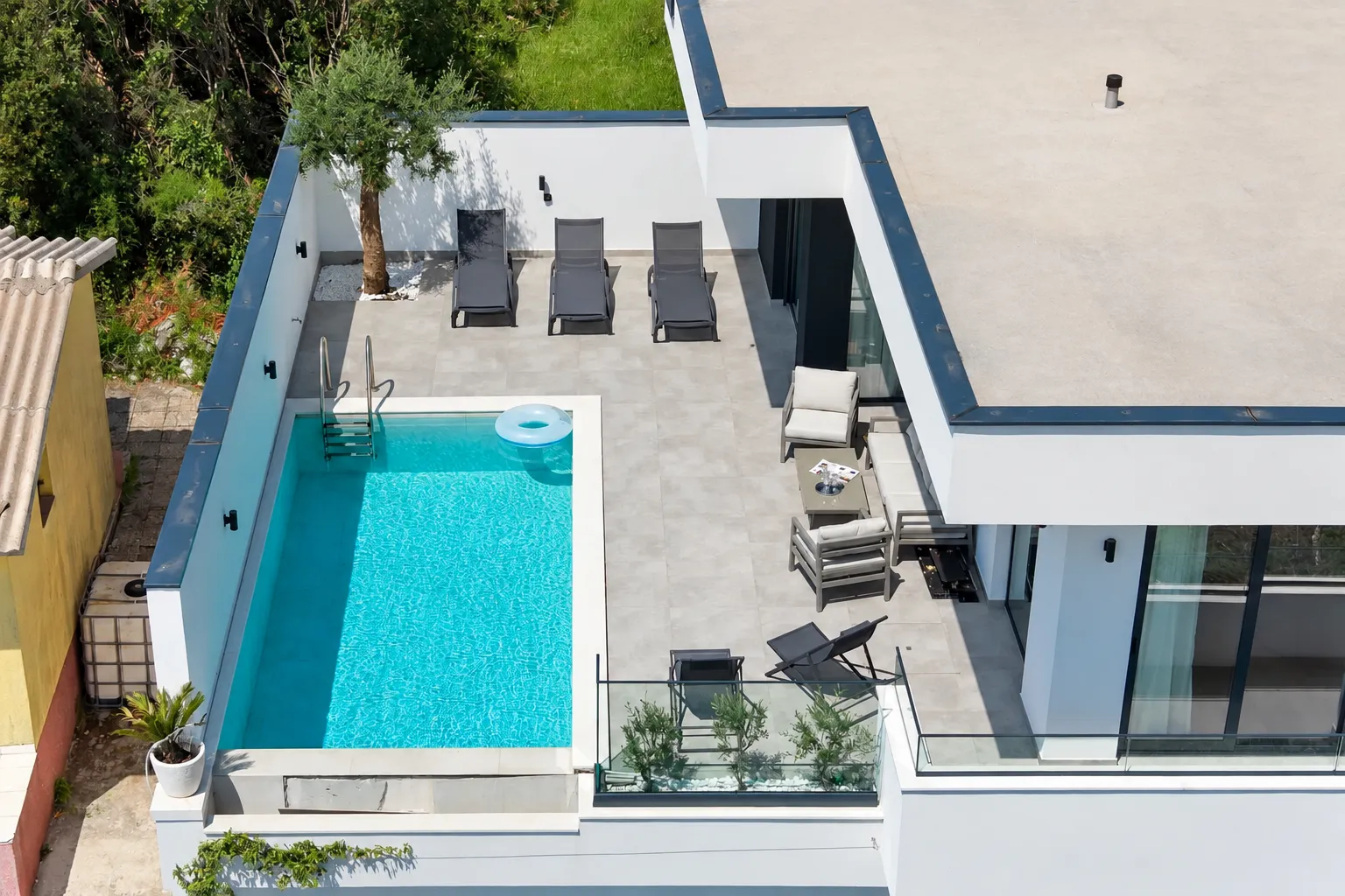 Top view of the terrace with a swimming pool and sun loungers.