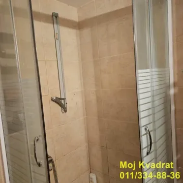 Tuš kabina sa staklenim vratima i pločicama u kupatilu. - image 8