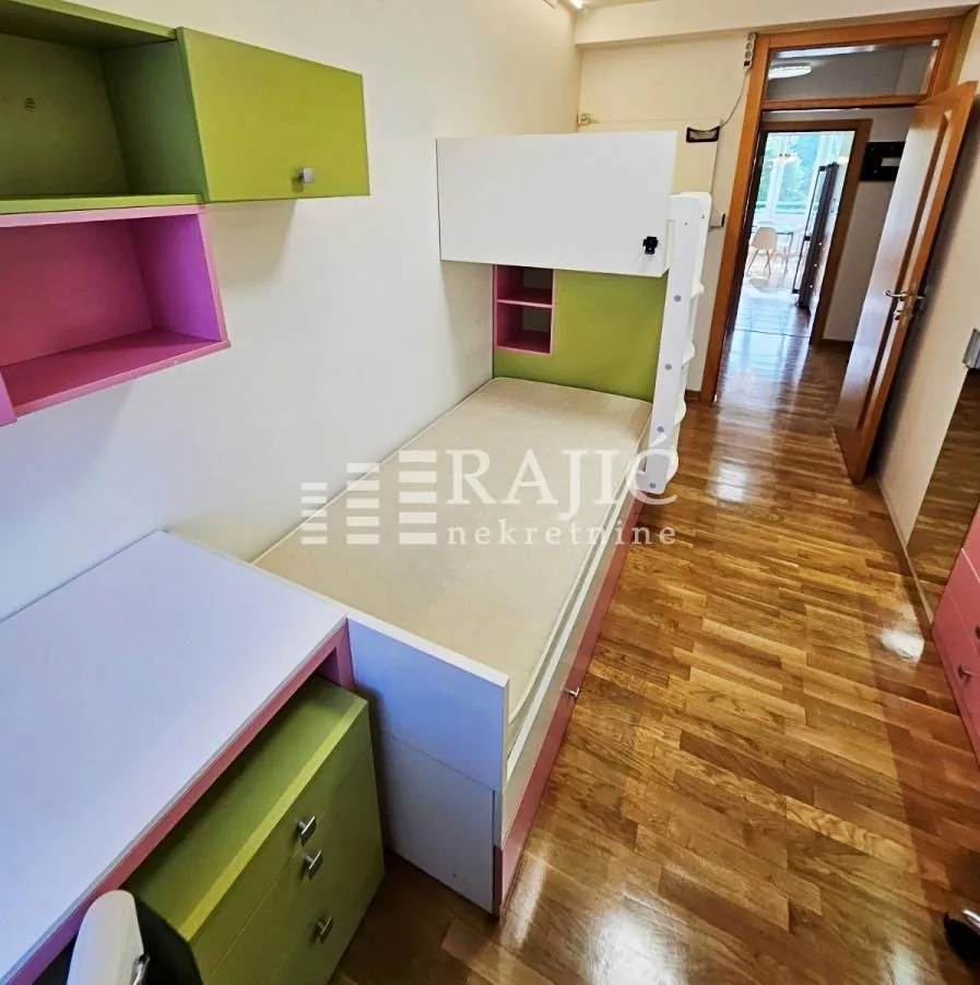Children's bedroom with a bunk bed and wooden flooring.