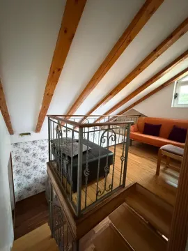 Potkrovlje sa drvenim gredama, kaučem i stepeništem sa ogradom od kovanog gvožđa. - image 10