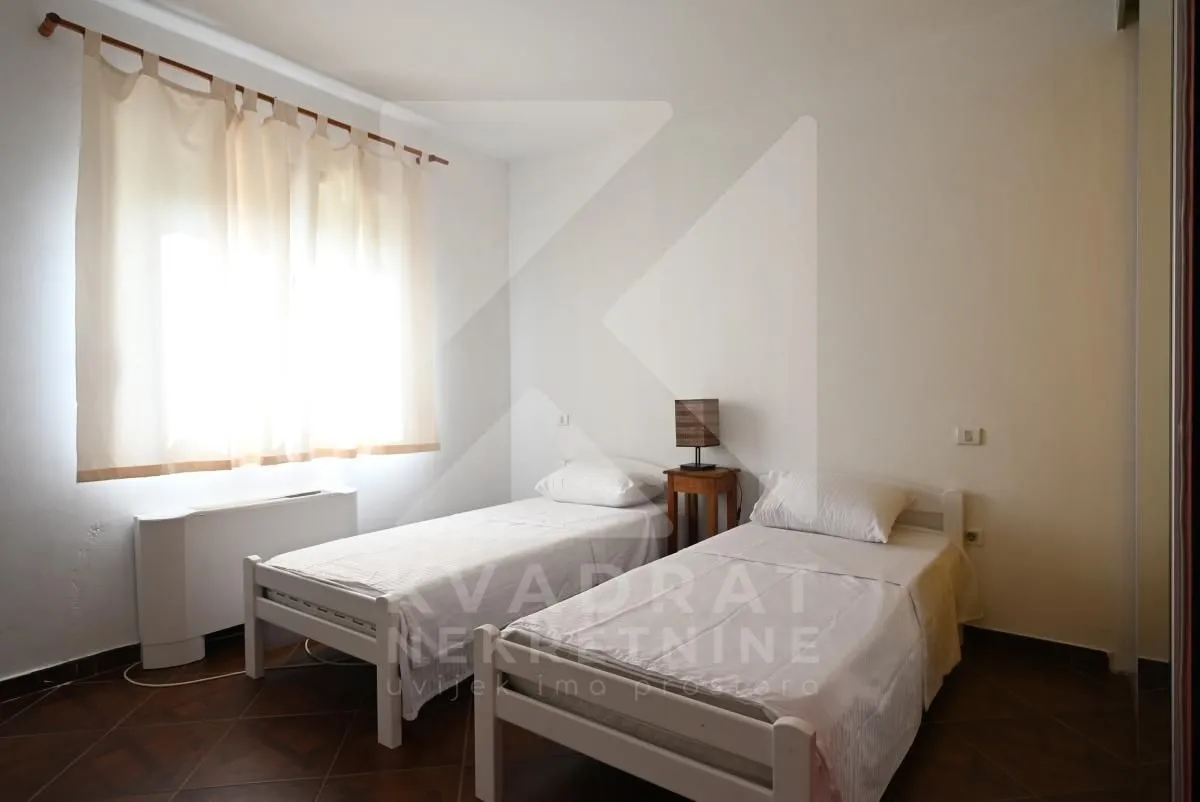 Bedroom with two single beds and a window.