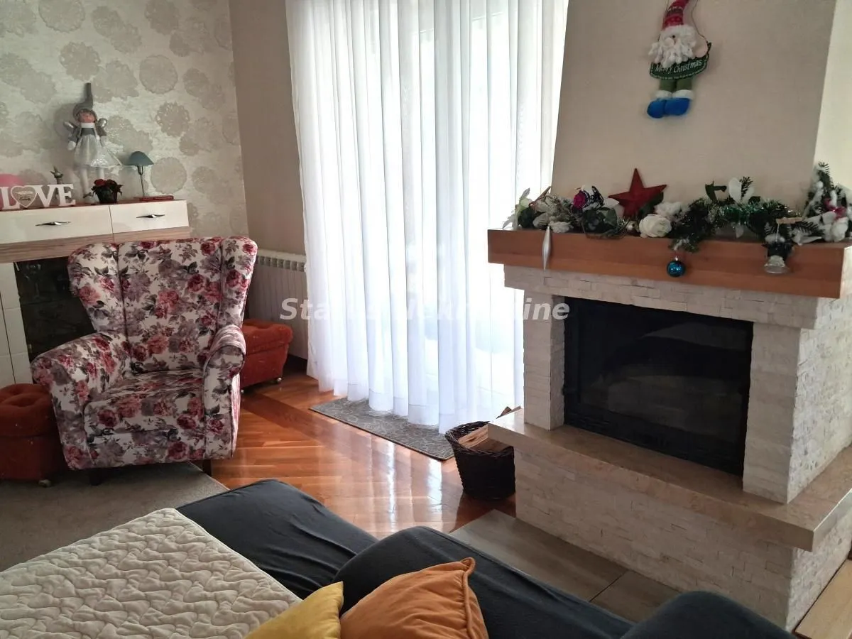 Dnevna soba sa kaminom i garniturom za sedenje.