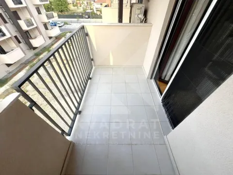 Pogled na prostrani balkon sa metalnom ogradom i keramičkim pločicama. - image 12