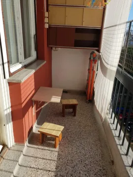 Uski balkon sa sklopivim stolom i drvenim stolicama. - image 13