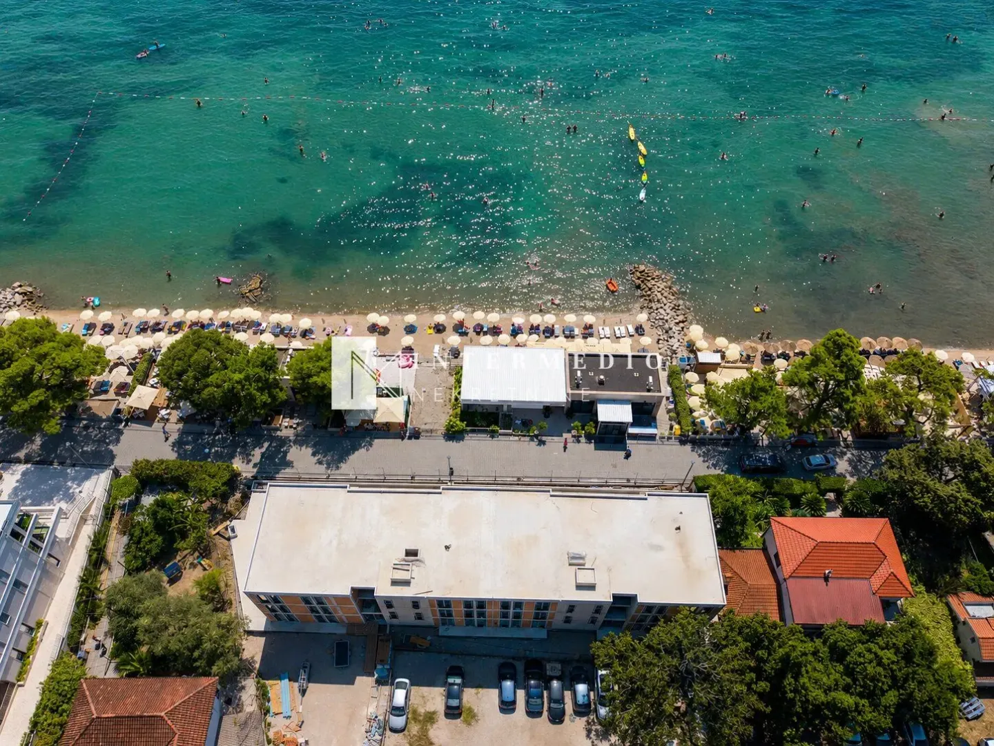 Pogled iz vazduha na zgradu blizu plaže i mora.