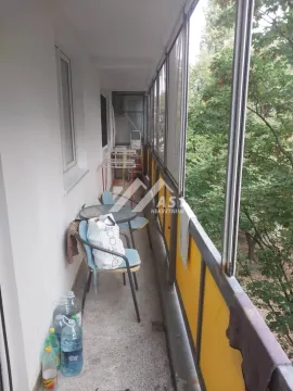 Dugačak zastakljeni balkon sa garniturom za sedenje i pogledom na zelenilo. - image 6