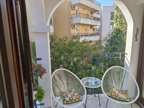 Furnished balcony with seating set and a view of surrounding buildings. - image 12