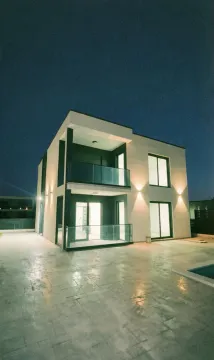 Eksterijer moderne dvospratne kuće sa osvetljenjem noću. - image 2