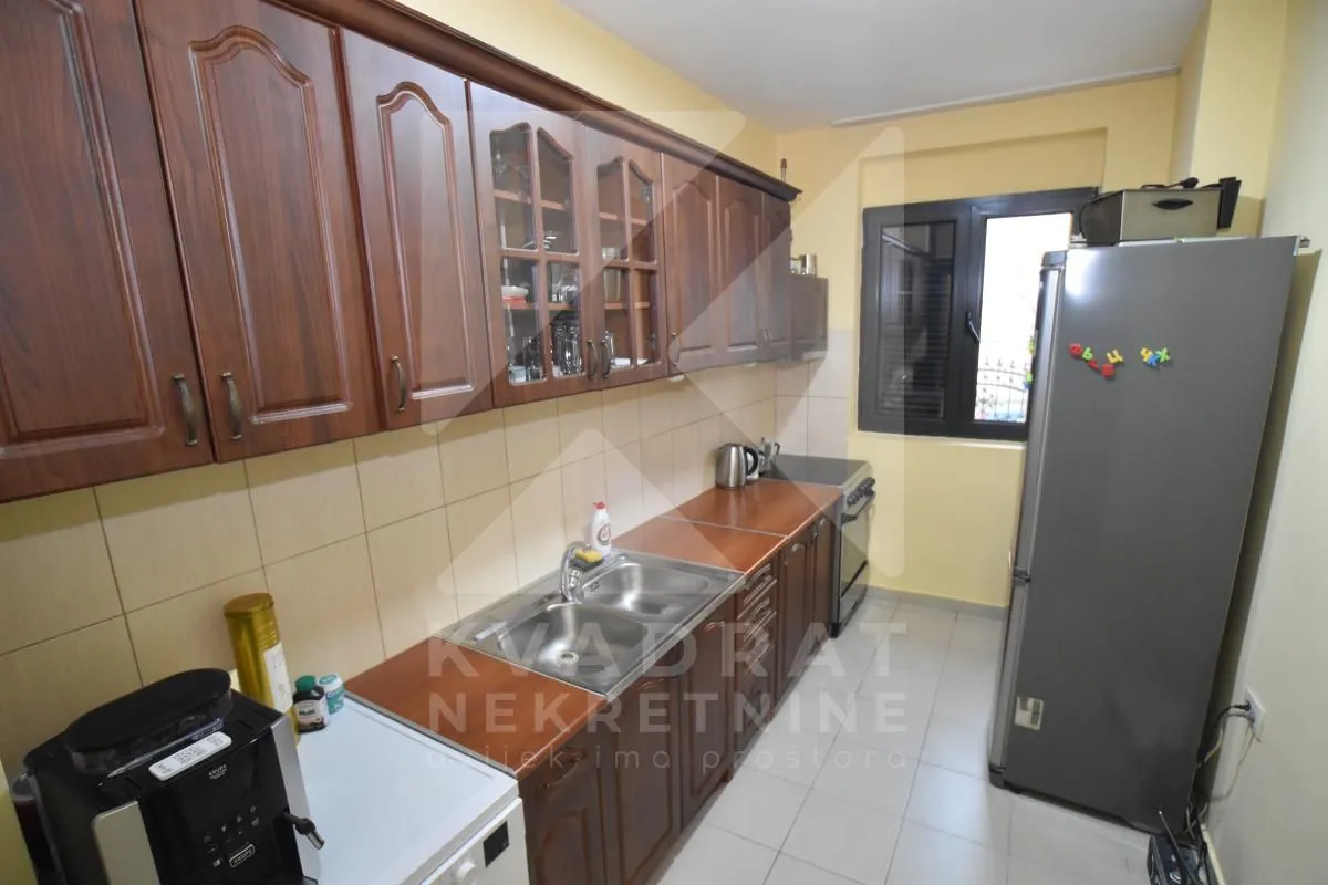 Kitchen with wooden cabinetry, a sink, and a large refrigerator.