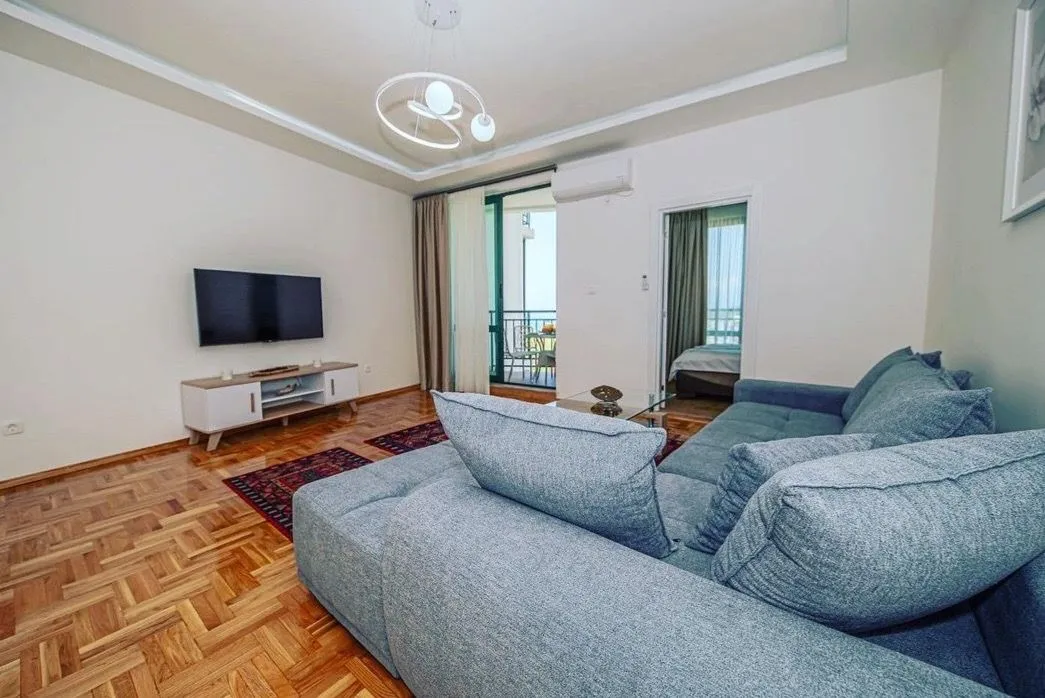 Living room with sofa, TV, and access to the terrace.