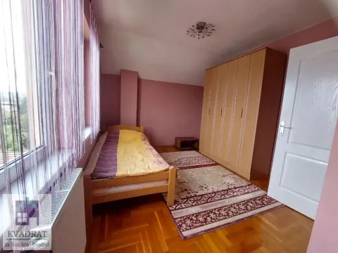 Furnished bedroom with a bed, wardrobe, and a window with curtains. - image 16