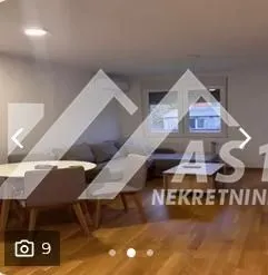 Dnevna soba sa garniturom, trpezarijskim stolom i parketom na podu.