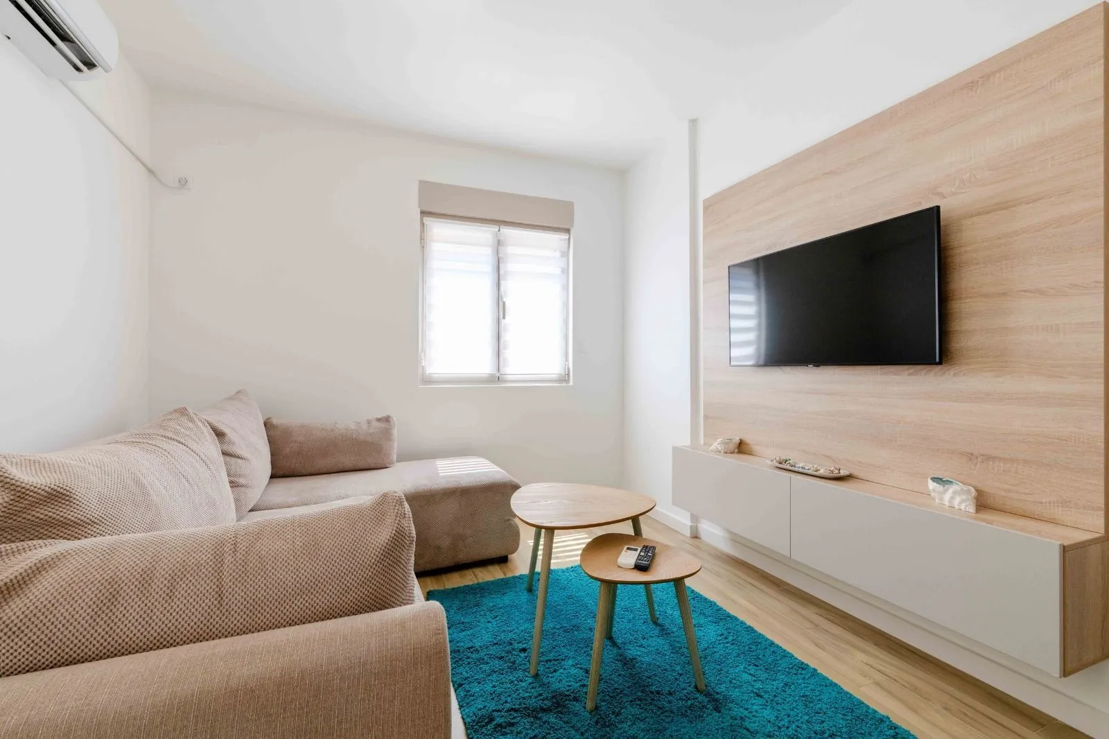 Cozy living room with a sectional sofa, TV, and wooden coffee tables.