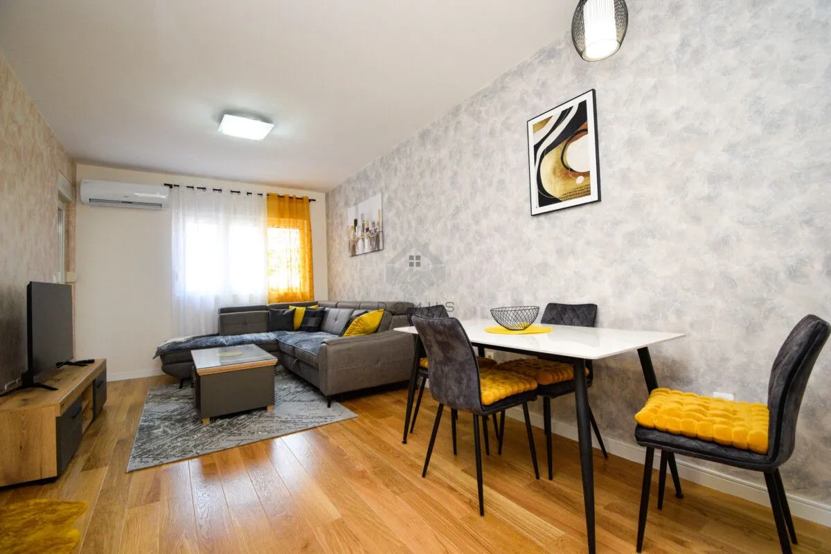 Living room with a sofa, TV, and dining table.