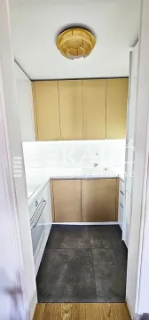 Small kitchen with gold cabinet fronts and a white countertop. - image 7