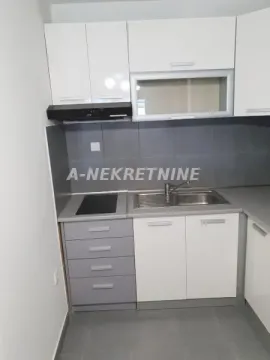 Manja kuhinja sa belim i sivim elementima, sudoperom i ugradnom pločom. - image 6