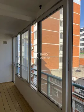 Zastakljeni balkon sa pogledom na susedne zgrade. - image 10