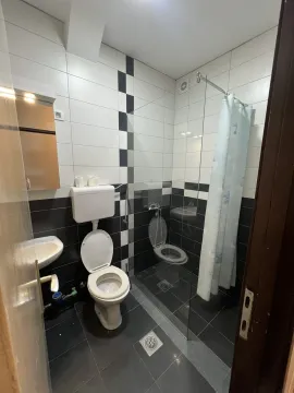 A simple bathroom with a walk-in shower and black and white tiles. - image 4