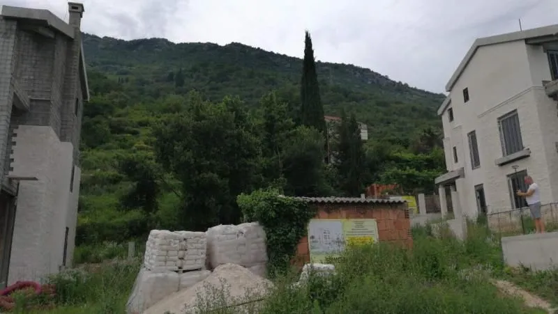 Pogled na spoljašnjost objekta u izgradnji i okolno zelenilo.