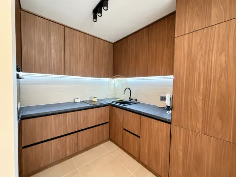 Modern kitchen with wooden cabinets and dark countertop. - image 7