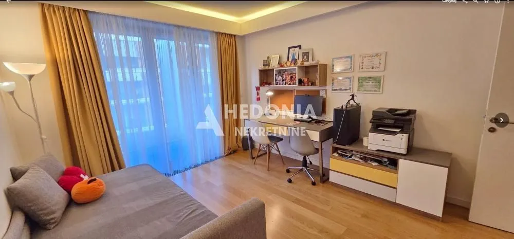 Manja spavaća soba sa krevetom, radnim stolom i izlazom na terasu.