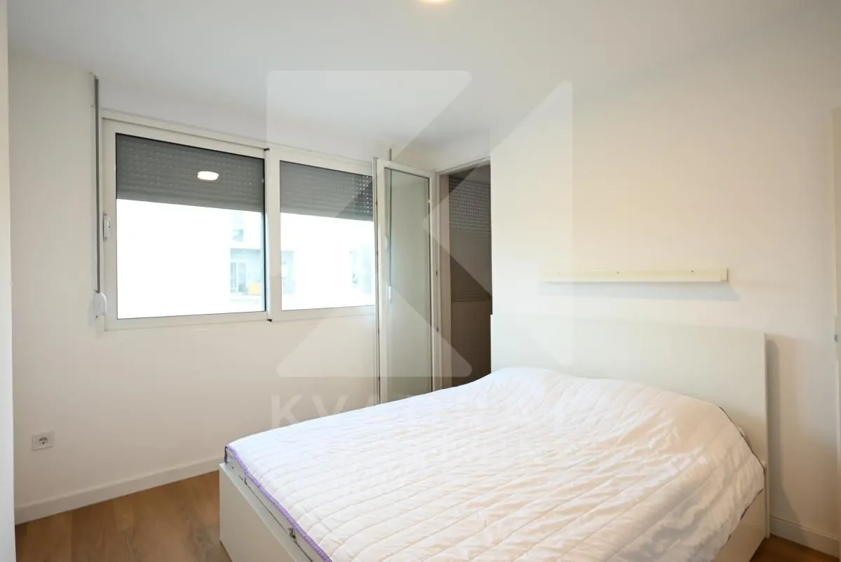Bright bedroom with a double bed and a window.