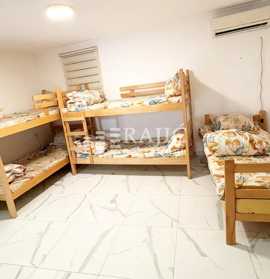 A bedroom with multiple wooden bunk beds.