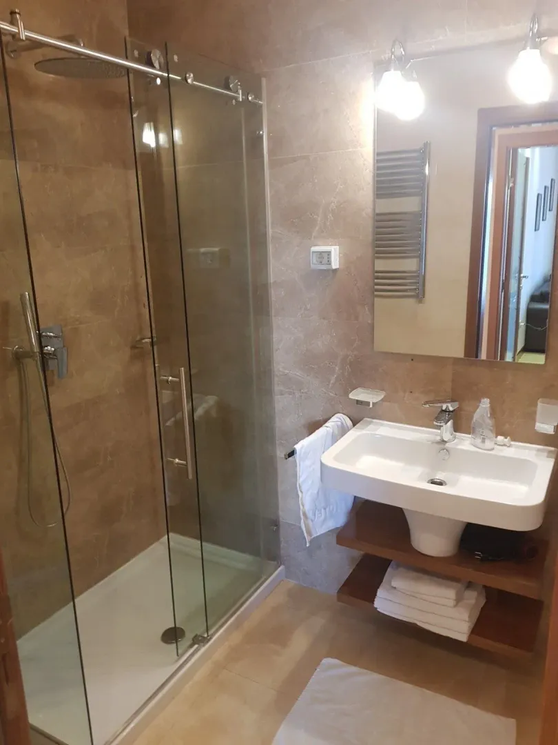 A modern bathroom featuring a glass shower cabin and a sink.