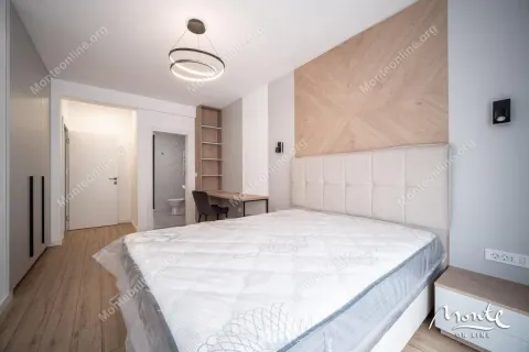 Moderna spavaća soba sa bračnim krevetom, radnim stolom i drvenim zidnim panelom. - image 17