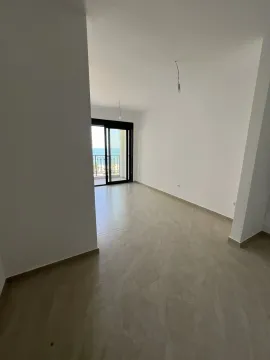 An empty and bright room with balcony access offering a view of the sea. - image 4