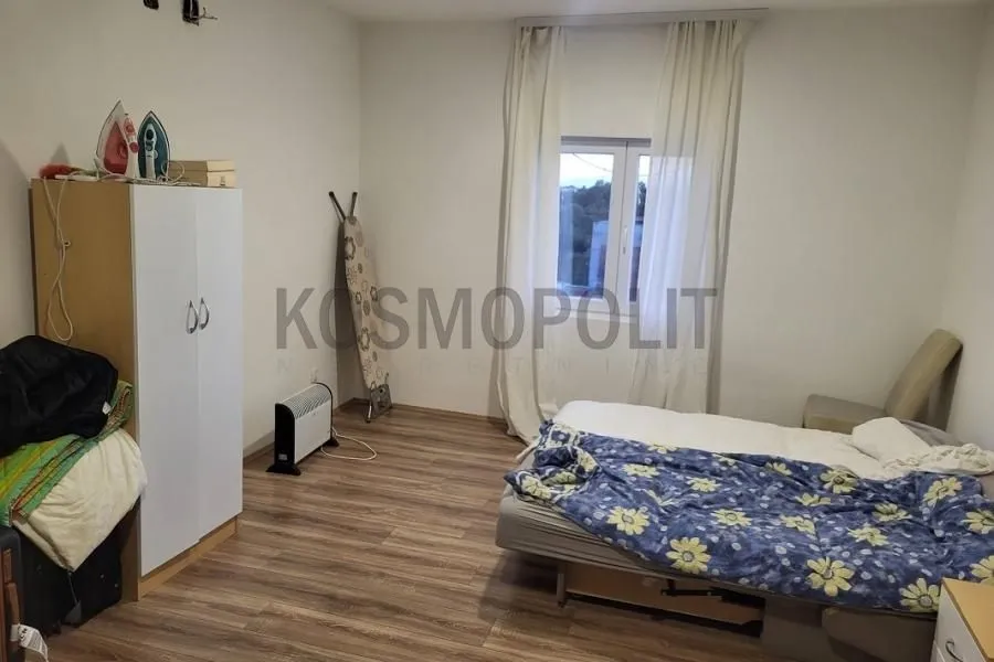 Furnished bedroom with a bed, wardrobe, and window.