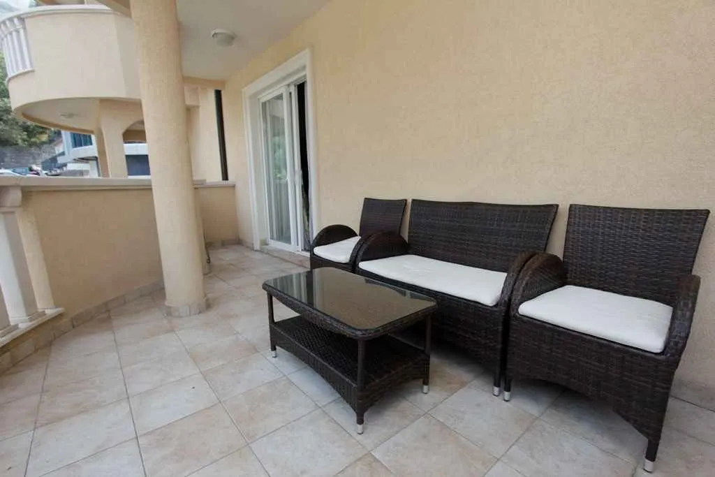 A spacious terrace with comfortable outdoor seating and a glass coffee table.