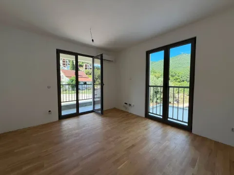 Prazna soba sa parketom i dvostrukim balkonskim vratima. - image 3