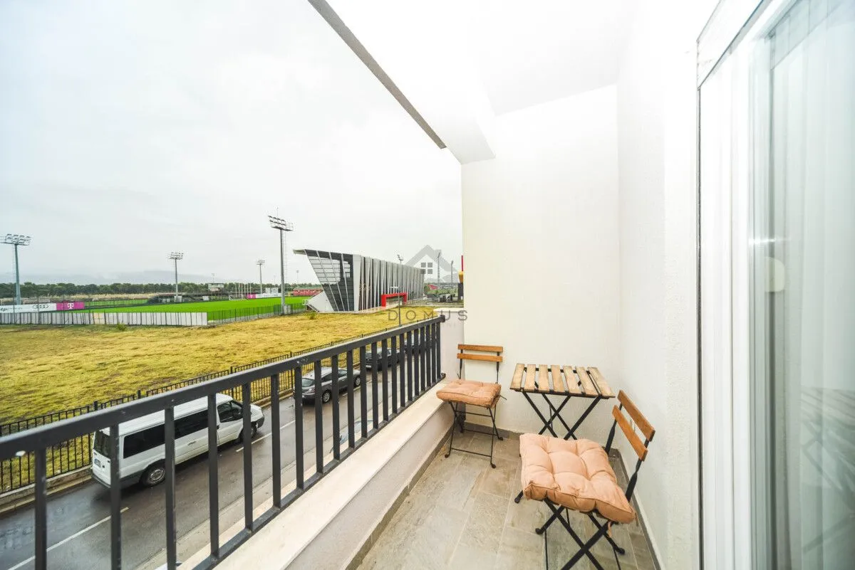 Unfurnished balcony with a table and two chairs and a view of the stadium.
