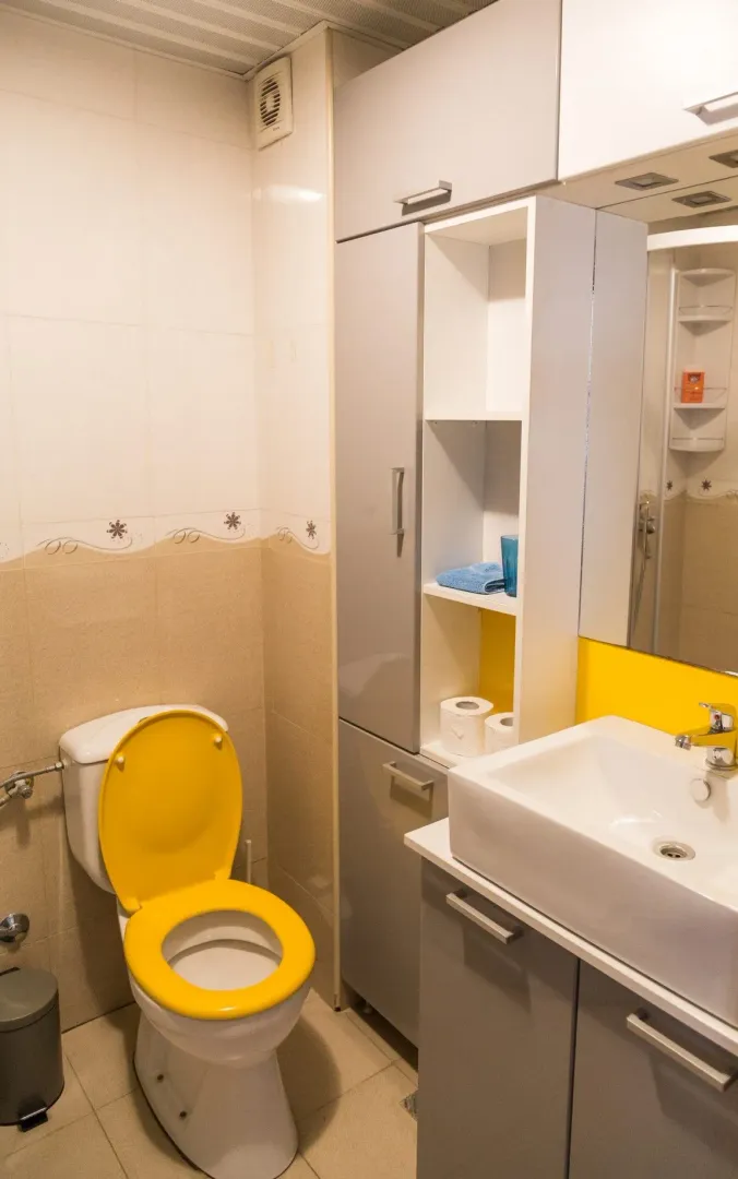 Manje kupatilo sa umivaonikom, WC šoljom i ugradnim ormarićem.