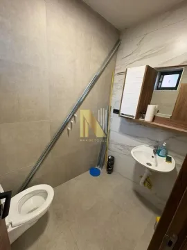 Smaller bathroom with a toilet, washbasin, and wall cabinet. - image 4