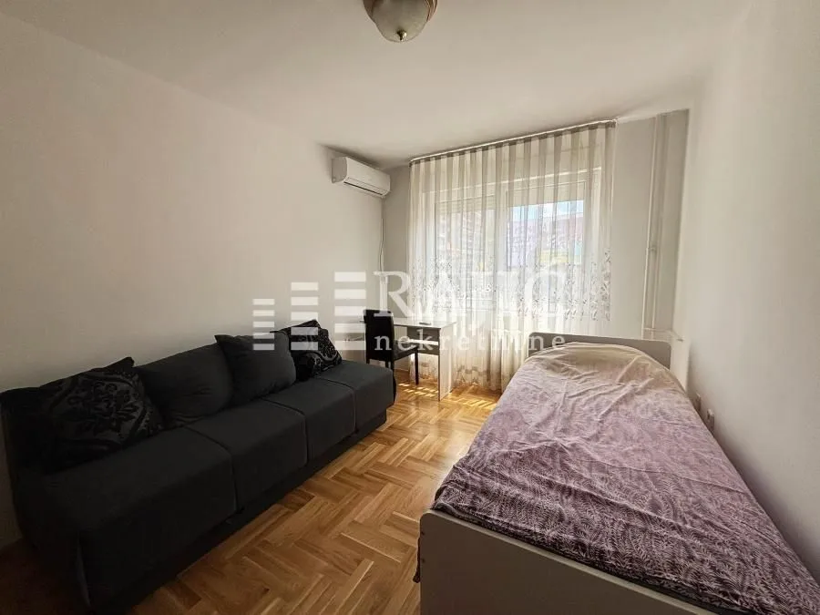Small bedroom with a bed, sofa, and a desk.
