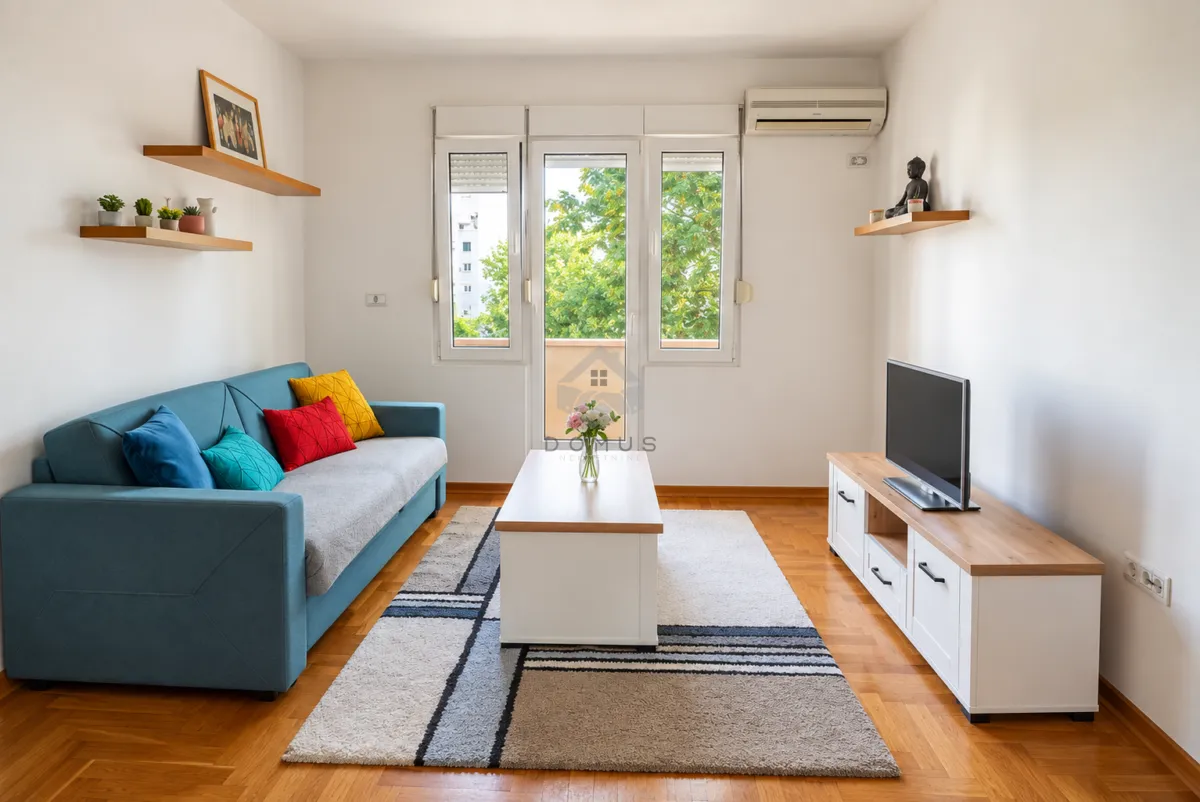 Living room with a blue sofa, coffee table and TV unit.