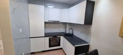 Moderna kuhinja sa bijelim elementima i tamnom radnom pločom. - image 7