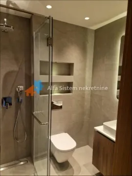 Modern bathroom with a walk-in shower, washbasin, and a wall-mounted toilet. - image 12