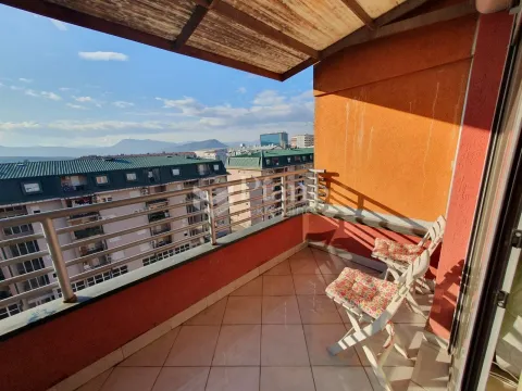 Covered balcony with a view of the city and surrounding buildings. - image 13