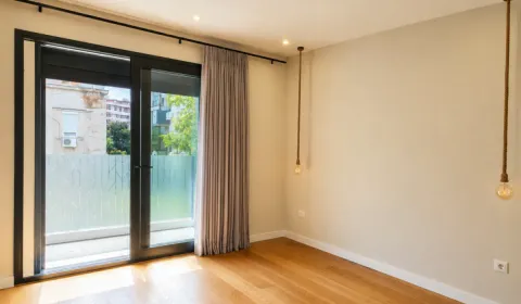 Prazna soba sa drvenim podom, visećim sijalicama i izlazom na terasu. - image 13