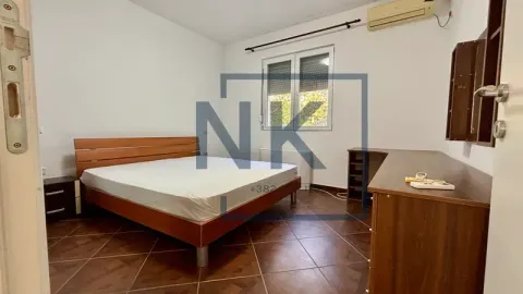 Furnished bedroom with a double bed, desk, and air conditioning. - image 12