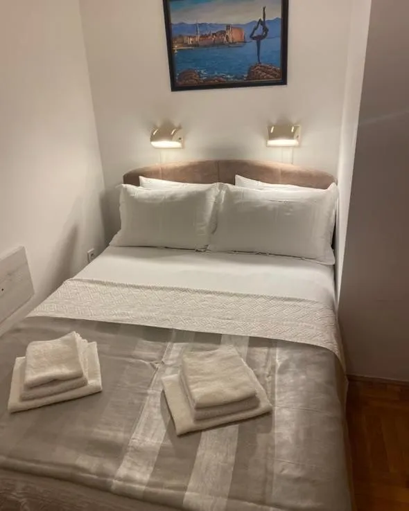 Furnished bedroom with a double bed and a painting on the wall.